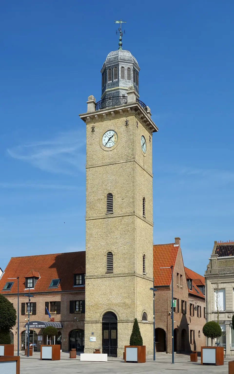 Le beffroi en briques et son horloge, au-dessus des maisons du centre-ville.